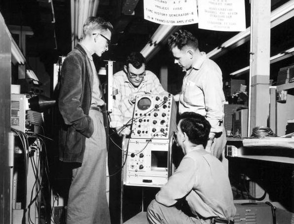 Employees at Radiation Inc. standing around an oscilloscope