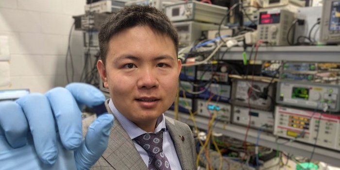 Dr. Xingyuan Xu with the microcomb chip